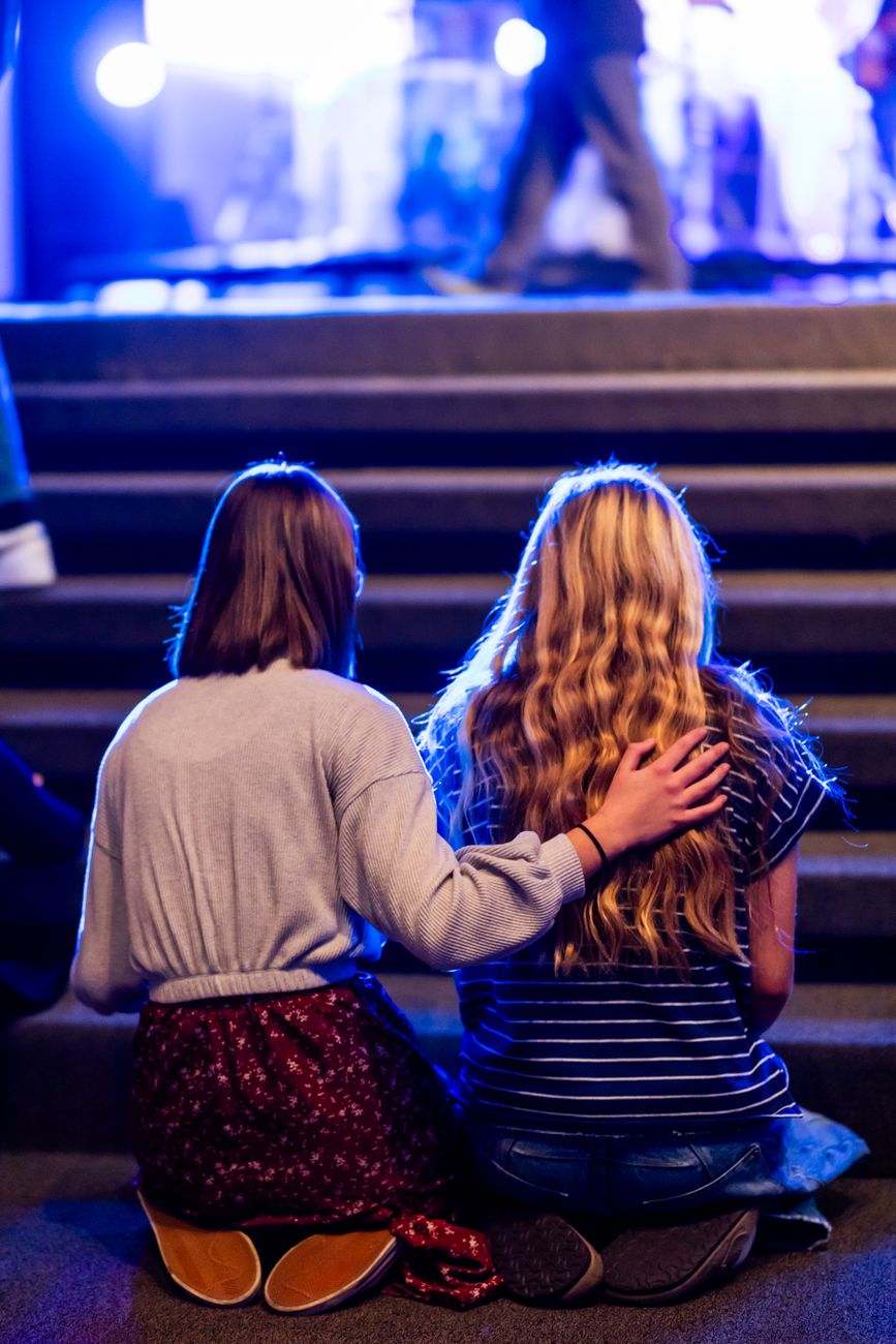 young women comforting each other at event