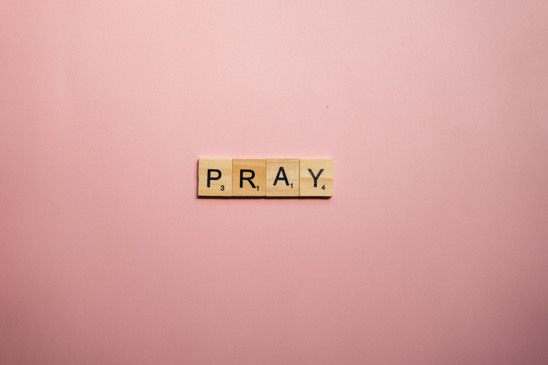 scrabble tiles on pink surface